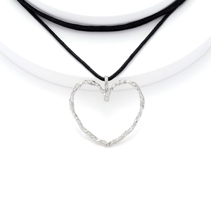 Macro shot of silver hollow heart pendant with textured finish on minimalist black cord