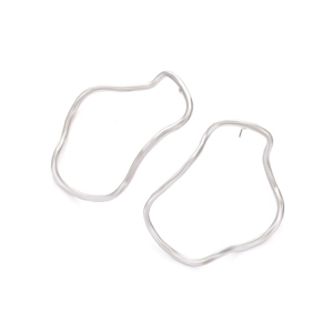 Macro detail of silver geometric irregular hoop earrings with a matte metallic finish