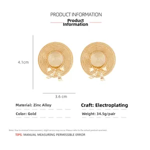 Macro detail of gold plated straw hat earrings with bow design and size specifications