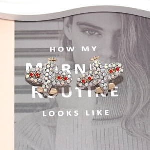 Boucles d'oreilles avion serties de strass brillants et étoile rouge sur magazine de mode