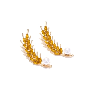 Golden wheat leaf earrings with yellow crystals and white pearl drops on white background