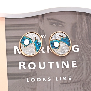 Abstract star and moon oval stud earrings with blue enamel finish on magazine