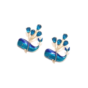 Cute whale earrings with blue enamel and crystal water drops on a white background