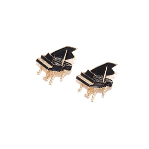 Detailed close-up of piano-shaped alloy earrings with black enamel and golden metal finish