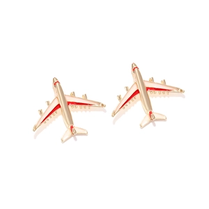 Creative airplane stud earrings with red and white enamel on a gold-tone base
