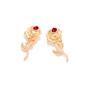 Baroque vintage gold rose drop earrings with ruby red stone center on white background