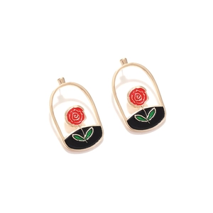Retro golden arch earrings featuring red enamel rose with green leaves on white background