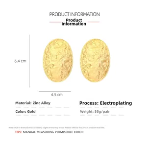 Detail view of large gold oval earrings with hammered texture and size measurements