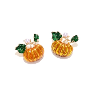 Halloween pumpkin earrings with orange enamel and white pearl accents on golden alloy