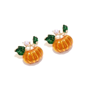 Detailed view of orange enamel pumpkin stud earrings with green leaves and white pearls