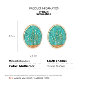 Detail view of 3.2x2.6cm enamel earrings with gold forest pattern and teal base