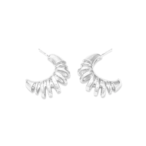 Détail de boucles d'oreilles créoles argentées en C avec texture nervurée en spirale