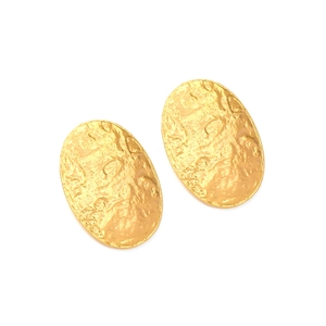 Detailed close-up of oval gold earrings featuring a vintage hammered metal texture finish