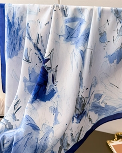 Detalle macro de elegante bufanda de seda con caída suave y diseño artístico azul