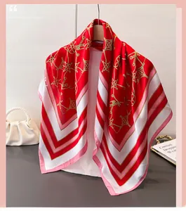 Detail of red silk-like scarf with gold chain print and elegant drape texture