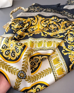 Close-up of Baroque silk scarf with ornate gold acanthus leaves and Greek key patterns