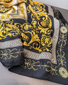 Detailed macro view of luxurious black silk scarf featuring golden baroque floral patterns