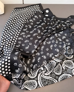Detailed view of paisley and polka dot print on silky monochrome square neck scarf