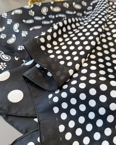 Detail of silk-satin scarf featuring paisley and polka dot patterns in black and white