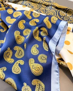 Detailansicht eines hochwertigen Satintuchs mit blauem Paisley und gelben Punktmustern