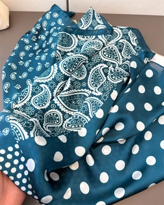 Detail of silk-like paisley scarf in peacock green with delicate white polka dots