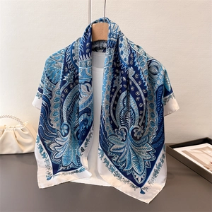Détail d'un foulard en satin bleu marine à motif paisley et imprimé éléphant sur cintre