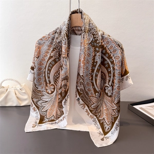 Détail d'un foulard en satin de soie avec motifs cachemire et imprimés d'animaux sauvages
