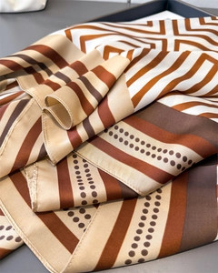 Close-up of geometric striped satin scarf texture with elegant rolled edge stitching