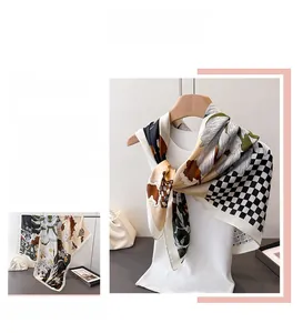 Détail d'un élégant foulard en satin color-block avec imprimé floral et carreaux vintage