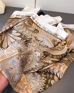 Détail d'un foulard en soie satinée vintage avec motifs cachemire et équestres