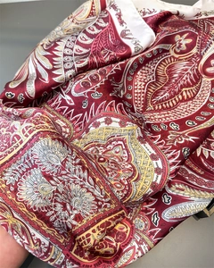 Gros plan du foulard en satin imprimé paisley montrant la texture et le drapé