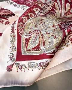 Gros plan du foulard en satin plié avec imprimés animaux exotiques et motifs floraux
