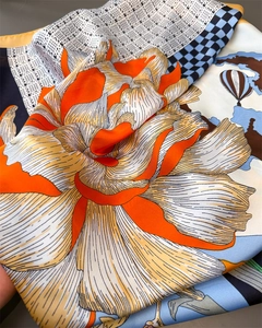 Détail d'un foulard en satin de soie avec imprimé floral et motifs pied-de-poule élégants
