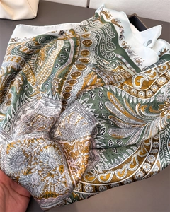 Détail d'un foulard en satin soyeux avec imprimés paisley et carrosses européens