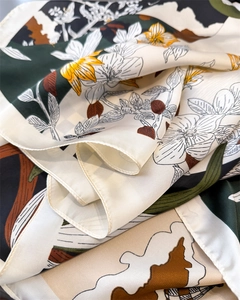 Détail du foulard en satin de soie avec imprimés floraux et bords roulés à la machine