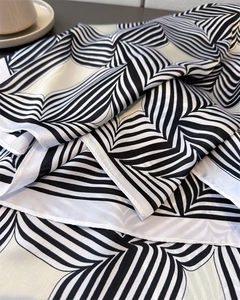 Detail eines Satin-Seidenschals mit markanten schwarz-weißen geometrischen Streifen