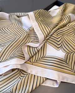 Nahaufnahme eines Satin-Seidentuchs mit geometrischem beige-schwarzem Radialmuster im Tablett