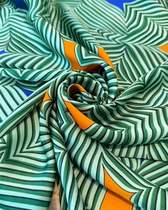 Detailaufnahme des Satin-Seidenschals mit geometrischem Muster und glänzender Textur