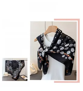 Detailed view of satin floral scarf featuring white camellia and chain patterns