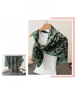 Detail of green and black patterned satin silk scarf with high gloss and drape