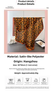 Detail of 90x90cm satin silk scarf featuring orange and black auspicious cloud patterns