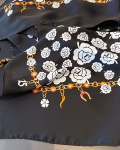 Detail of silk-like satin scarf featuring white camellias and gold chain pattern