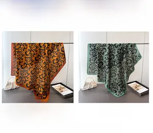 Detail view of orange and green satin scarves featuring retro cloud patterns