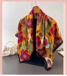 Detail of silk satin scarf with red floral prints and yellow base color for women