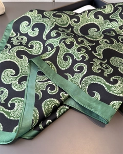 Detail of silk-satin scarf featuring deep green paisley print and hand-rolled edges