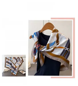 Detail of satin scarf with chain geometric print hanging on a wooden hanger