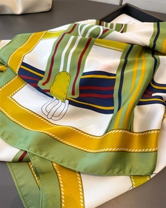 Close-up of equestrian silk scarf with leather belt patterns and fine edge stitching