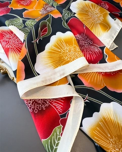 Detail of premium floral faux silk scarf showing vibrant prints and fine rolled edges