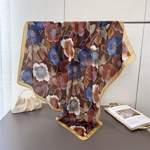 Elegant floral silk-like scarf with large brown blossoms draped over a golden stand