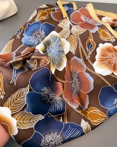 Detailed view of bohemian floral print on silk-like scarf with hand-rolled edges